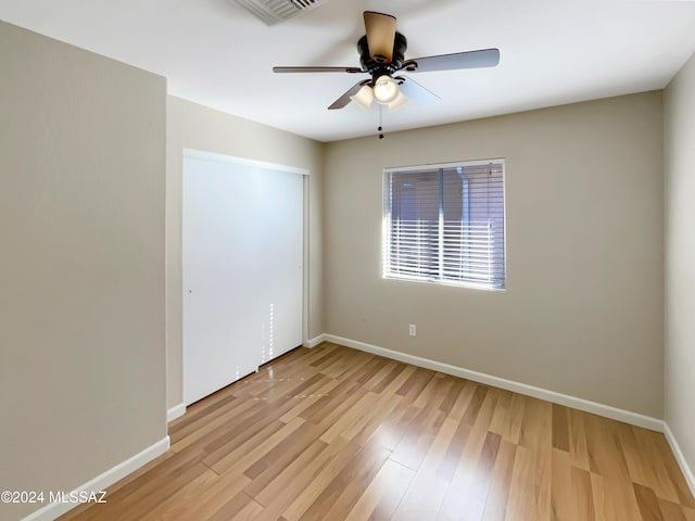 empty room with ceiling fan and light hardwood / wood-style floors