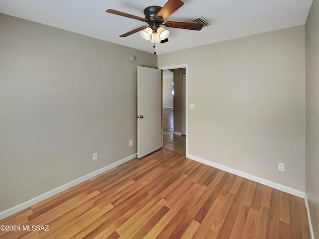 empty room with ceiling fan and light hardwood / wood-style floors