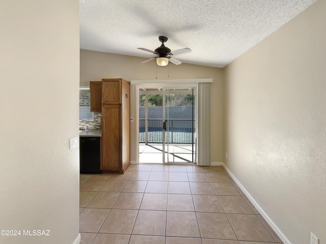 unfurnished dining area featuring light tile patterned floors, a textured ceiling, ceiling fan, and lofted ceiling