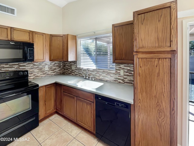 kitchen with tasteful backsplash, sink, light tile patterned flooring, and black appliances