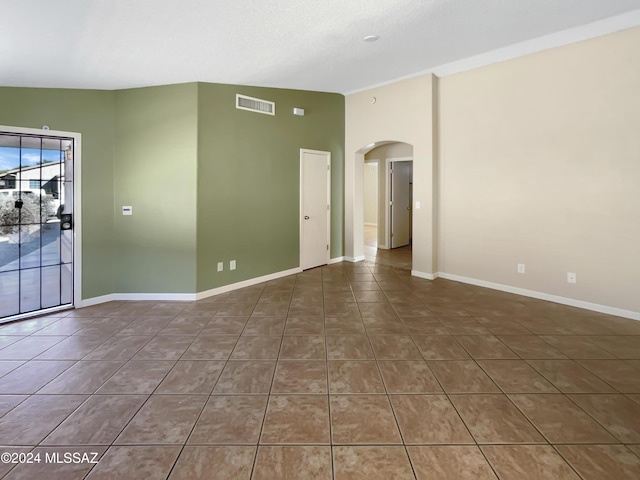 spare room featuring dark tile patterned floors