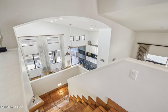 staircase with tile patterned floors, vaulted ceiling, and ceiling fan