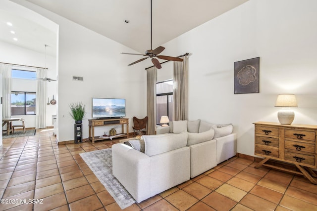 tiled living room featuring ceiling fan and high vaulted ceiling