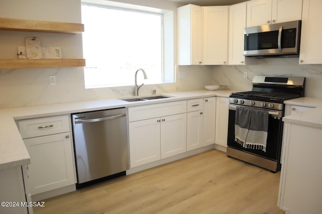 kitchen with white cabinets, backsplash, sink, and appliances with stainless steel finishes