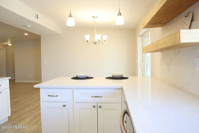 kitchen with a chandelier, light hardwood / wood-style floors, white cabinetry, and hanging light fixtures