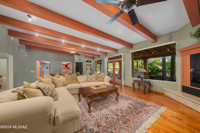 living room featuring beamed ceiling, ceiling fan, french doors, and light hardwood / wood-style flooring