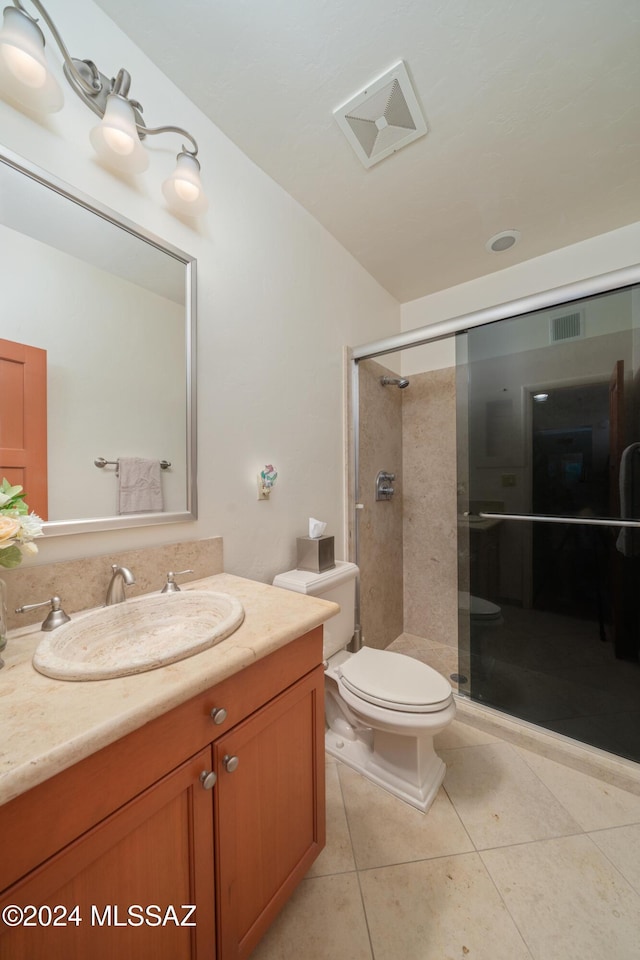 bathroom featuring toilet, a shower with door, vanity, and tile patterned flooring