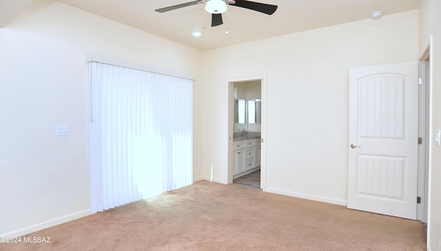 unfurnished bedroom featuring ensuite bathroom, ceiling fan, and light carpet