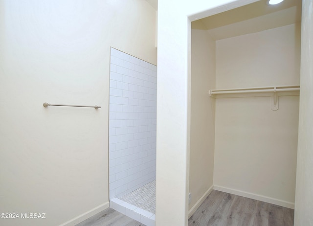 bathroom with hardwood / wood-style floors and tiled shower