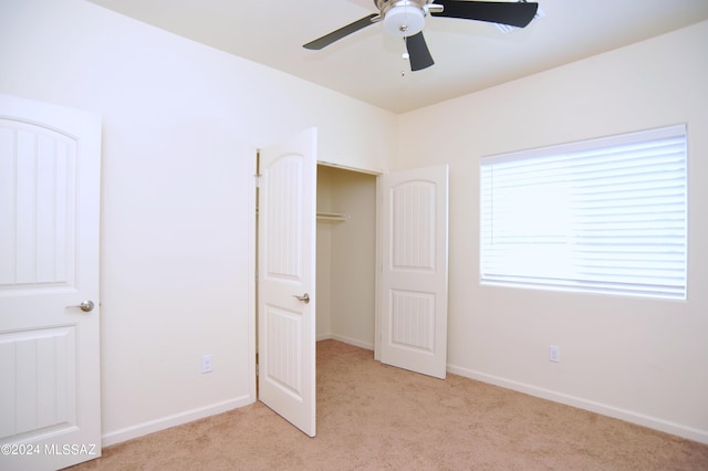 unfurnished bedroom featuring ceiling fan, light carpet, and a closet