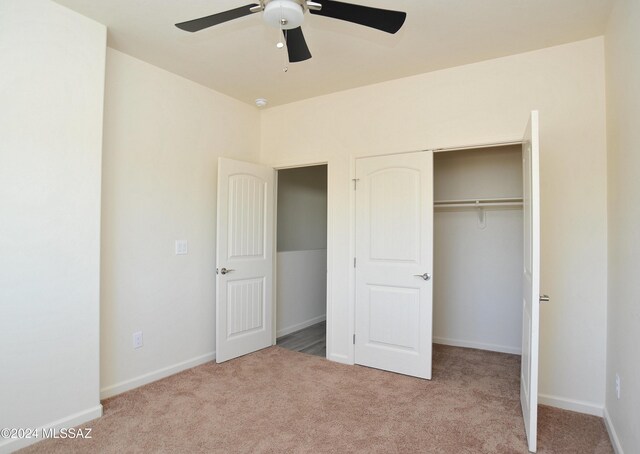 unfurnished bedroom featuring ceiling fan, light carpet, and a closet