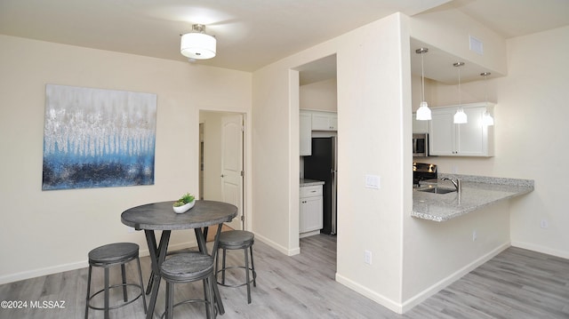 dining space featuring light hardwood / wood-style flooring and sink