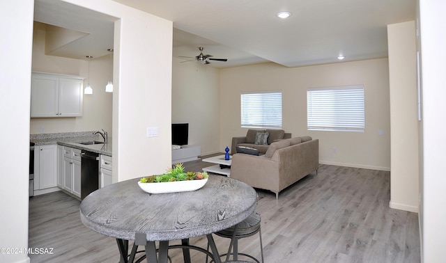 dining room featuring light wood-type flooring, ceiling fan, and sink