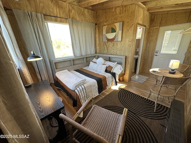 bedroom featuring hardwood / wood-style flooring and wood walls