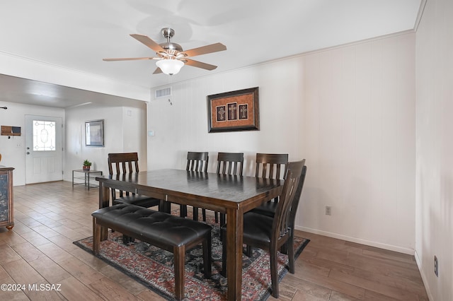 dining space featuring hardwood / wood-style floors, ceiling fan, and crown molding