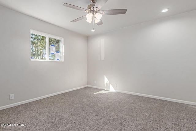 carpeted spare room with ceiling fan