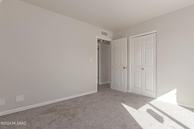 unfurnished bedroom with carpet and a closet