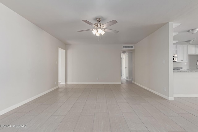 empty room with ceiling fan and light hardwood / wood-style flooring