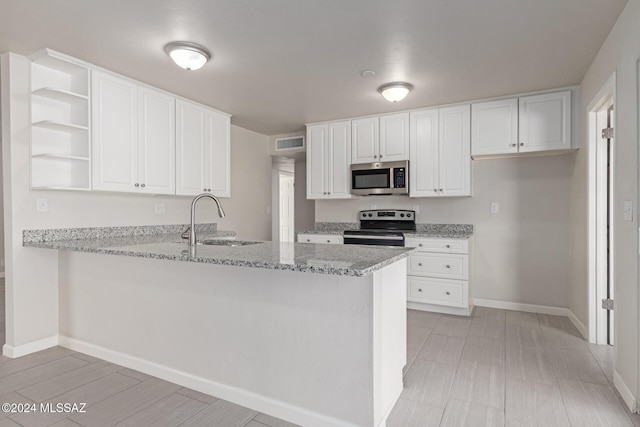 kitchen with white cabinets, sink, light stone counters, kitchen peninsula, and stainless steel appliances