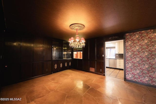 unfurnished dining area with an inviting chandelier