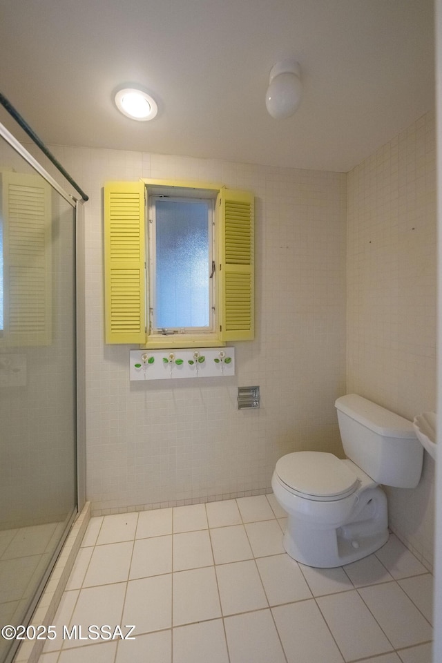 bathroom with tile walls, toilet, walk in shower, and tile patterned flooring