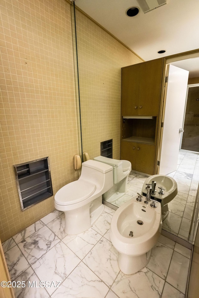 bathroom with toilet and a bidet