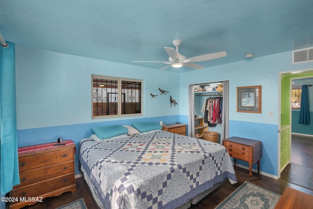 bedroom with dark wood-type flooring, multiple windows, and a closet