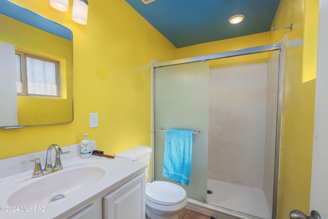 bathroom featuring tile patterned floors, vanity, toilet, and a shower with shower door