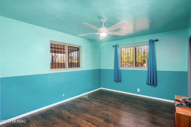 unfurnished room with ceiling fan and dark hardwood / wood-style flooring