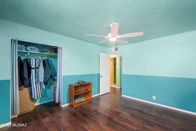 unfurnished bedroom featuring ceiling fan, dark hardwood / wood-style flooring, and a closet