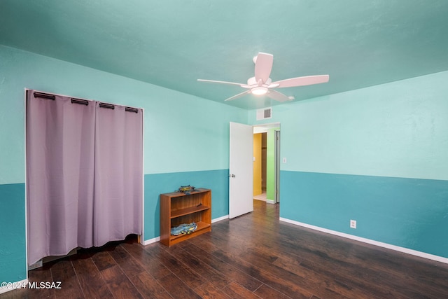 empty room with ceiling fan and dark hardwood / wood-style flooring