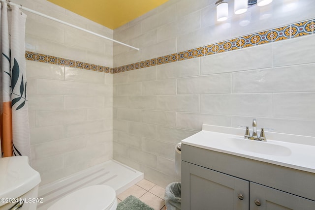 bathroom featuring a shower with curtain, tile patterned floors, toilet, vanity, and tile walls