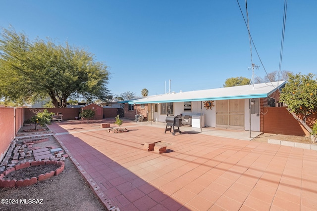 back of property featuring a patio area and a fire pit