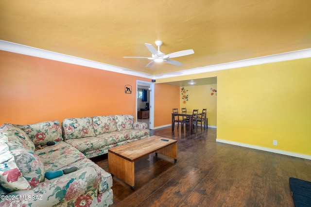 living room with ceiling fan, ornamental molding, and dark wood-type flooring