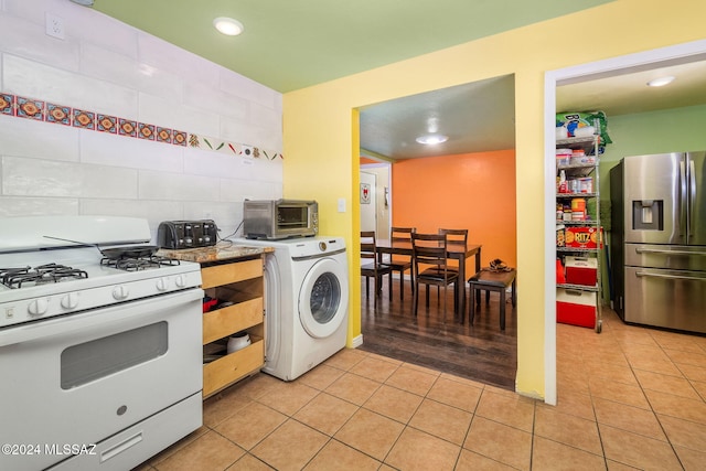 kitchen with washer / clothes dryer, stainless steel fridge with ice dispenser, white range with gas stovetop, and light wood-type flooring