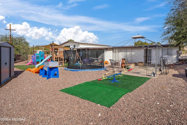 view of play area featuring a storage unit, a patio area, and a trampoline