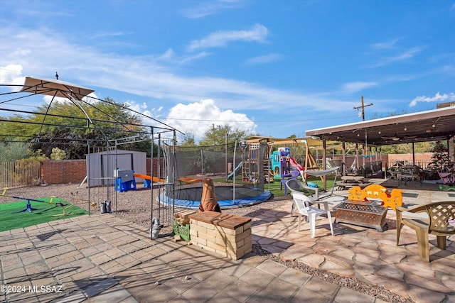 view of patio / terrace featuring a playground, a trampoline, and a storage shed