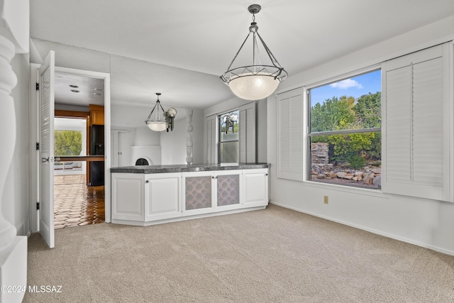 kitchen featuring carpet flooring, plenty of natural light, and pendant lighting