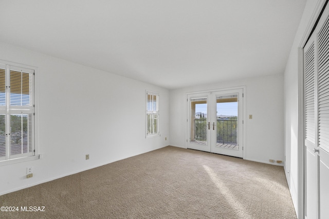 unfurnished bedroom with access to exterior, french doors, carpet floors, and a closet