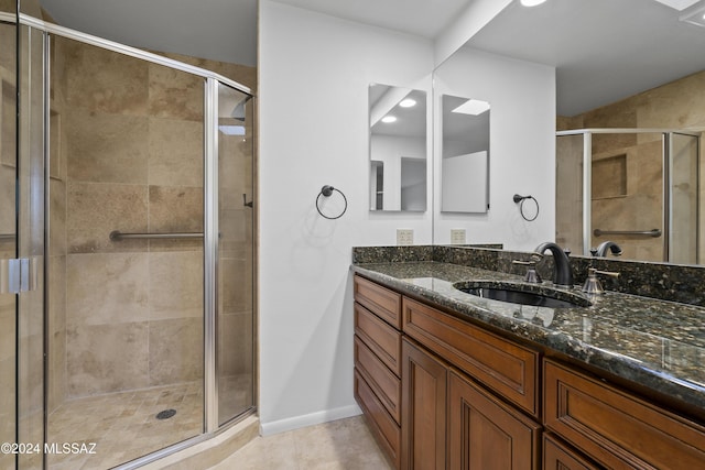 bathroom with tile patterned flooring, vanity, and walk in shower