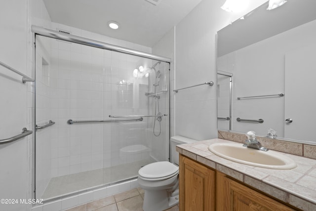 bathroom with tile patterned flooring, vanity, toilet, and walk in shower