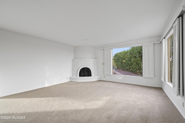 unfurnished living room with carpet flooring and a large fireplace