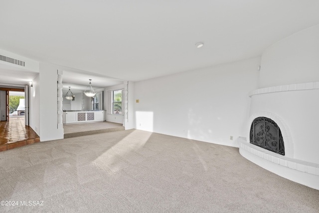 unfurnished living room featuring light colored carpet and a fireplace