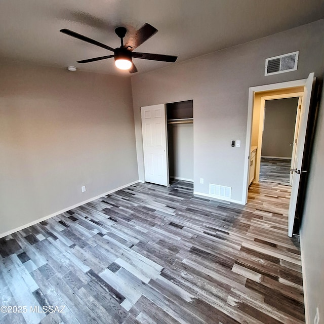 unfurnished bedroom featuring ceiling fan, a closet, and wood-type flooring