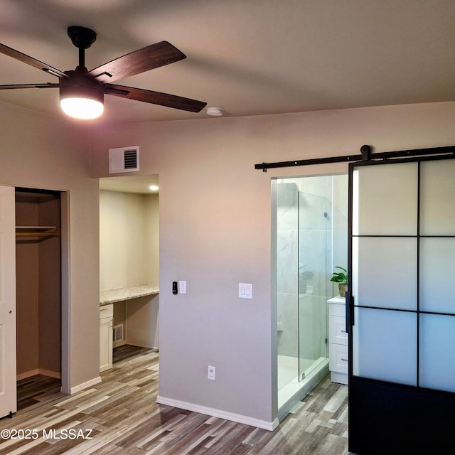 bathroom featuring ceiling fan, tiled shower, and hardwood / wood-style floors