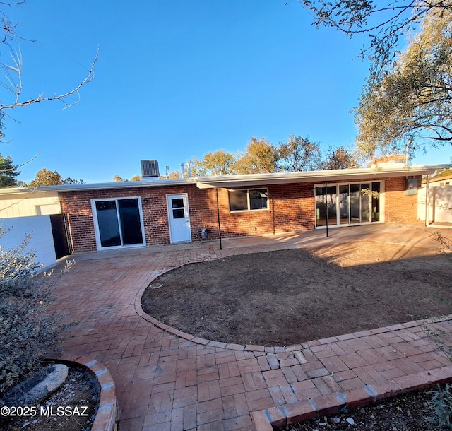 rear view of property featuring central air condition unit and a patio area