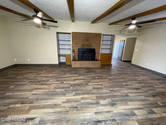 unfurnished living room with beam ceiling, dark hardwood / wood-style flooring, and a brick fireplace