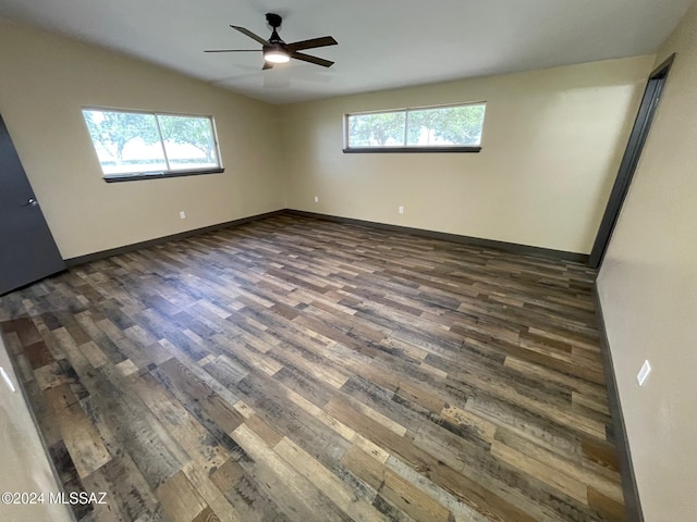 spare room with dark hardwood / wood-style floors, vaulted ceiling, and ceiling fan