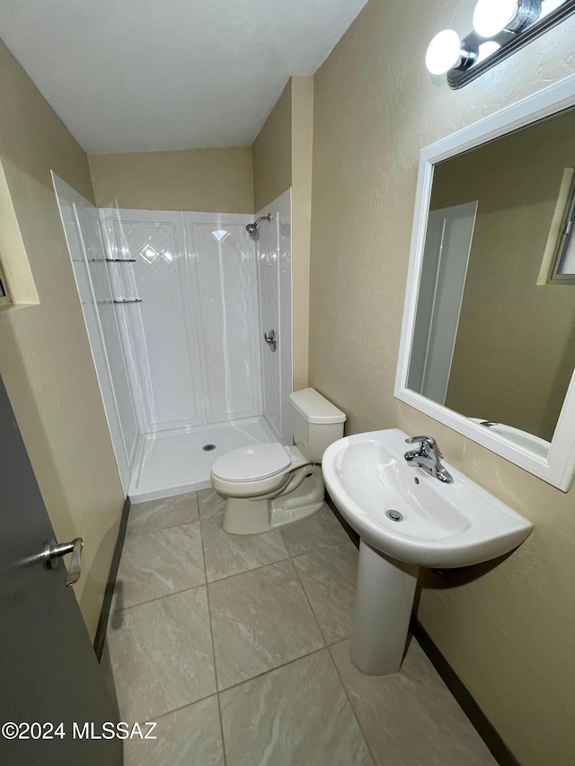 bathroom featuring tile patterned floors, a shower, sink, and toilet