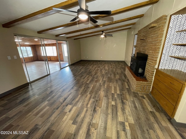 unfurnished living room featuring a wood stove, ceiling fan, beamed ceiling, and dark hardwood / wood-style floors